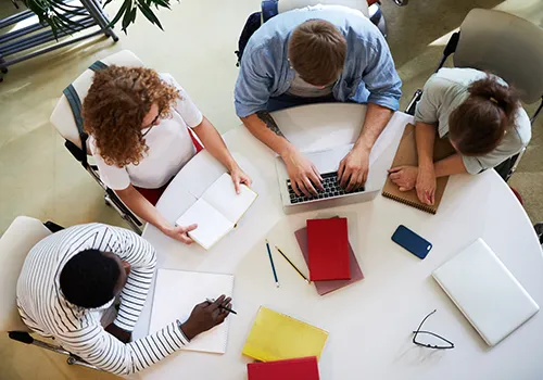 Azubis sitzen gemeinsam am Besprechungstisch