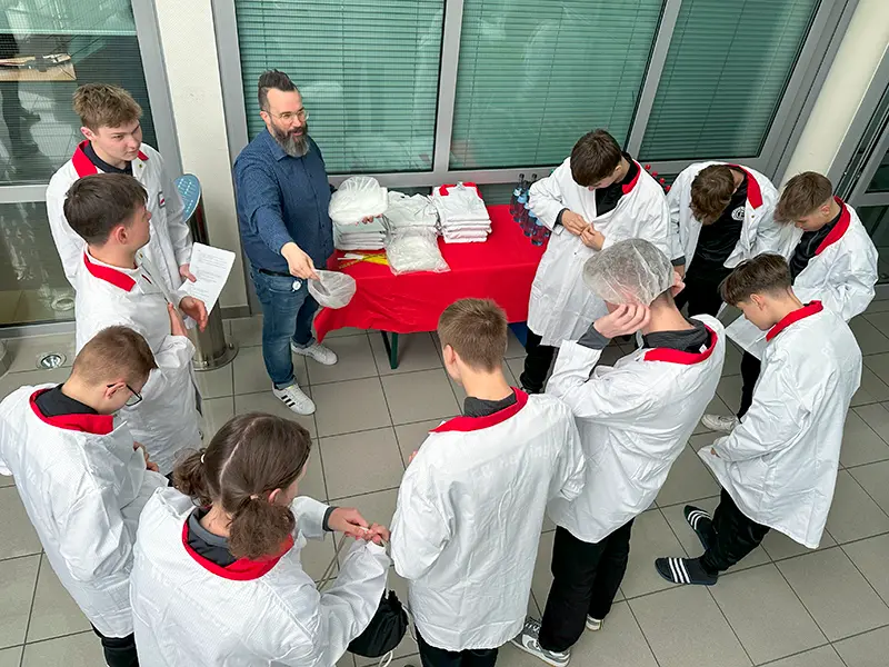 Fußballmannschaft FC Hettingen kleidet sich für den Firmenrundgang bei Hoffmann + Krippner ein