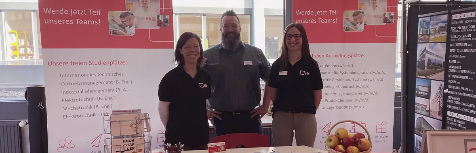 drei Mitarbeiter von H+K stehen am eigenen Stand auf der Ausbildungsmesse
